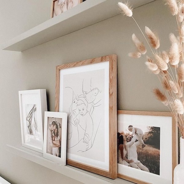 Fotovæg med familiebilleder, med en Line Art tegning af en ung familie, Instagram opslag af @adriane