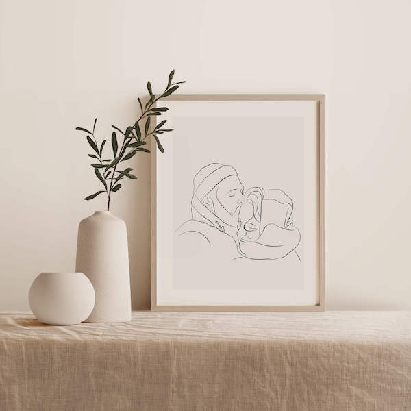Line Art tegning af et par, tegningen står i en ramme på et bord ved siden af en plante
